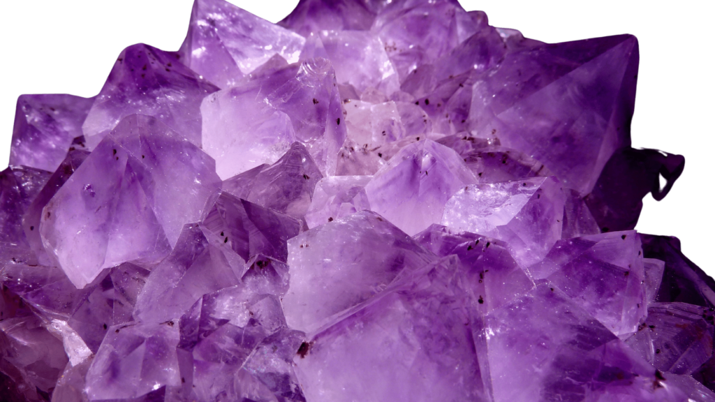 A close-up of purple amethyst crystals with sharp, jagged formations, these Reiki crystals invite you to embark on a healing journey.