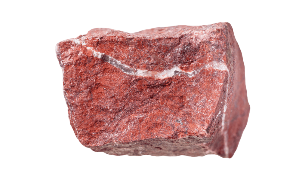 A rough, rectangular piece of red jasper stone with white veins is featured prominently against a pristine white background, symbolizing a pivotal element in a healing journey through Reiki crystals.