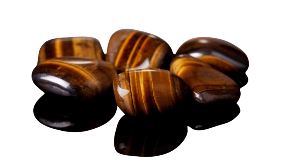 Five polished tiger's eye stones with brown and golden stripes are arranged against a white background, perfect for enhancing your healing journey with Reiki crystals.